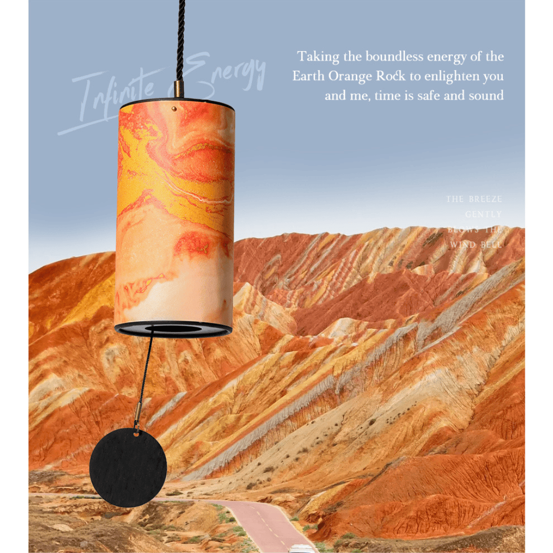 Orange rock-patterned wind chime with black striker, set against desert hills — healing sound for peace and connection