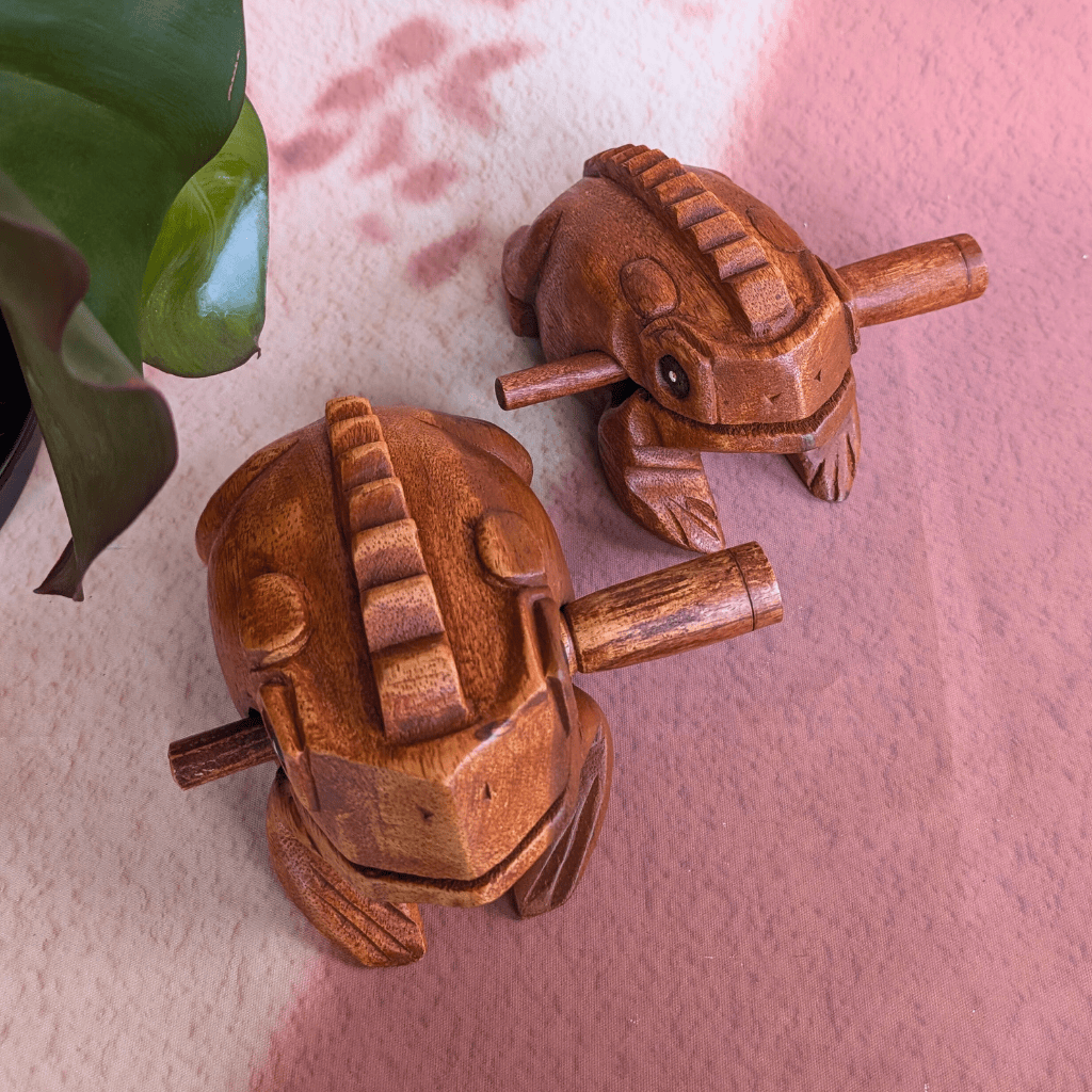 Hand-carved wooden frog percussion instruments with natural grain, perfect for rhythmic healing music and mindful play.