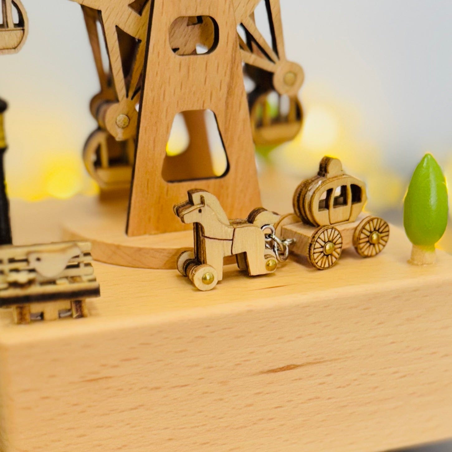 Wooden music box with horse-drawn carriage, Ferris wheel, and green tree, warm lights