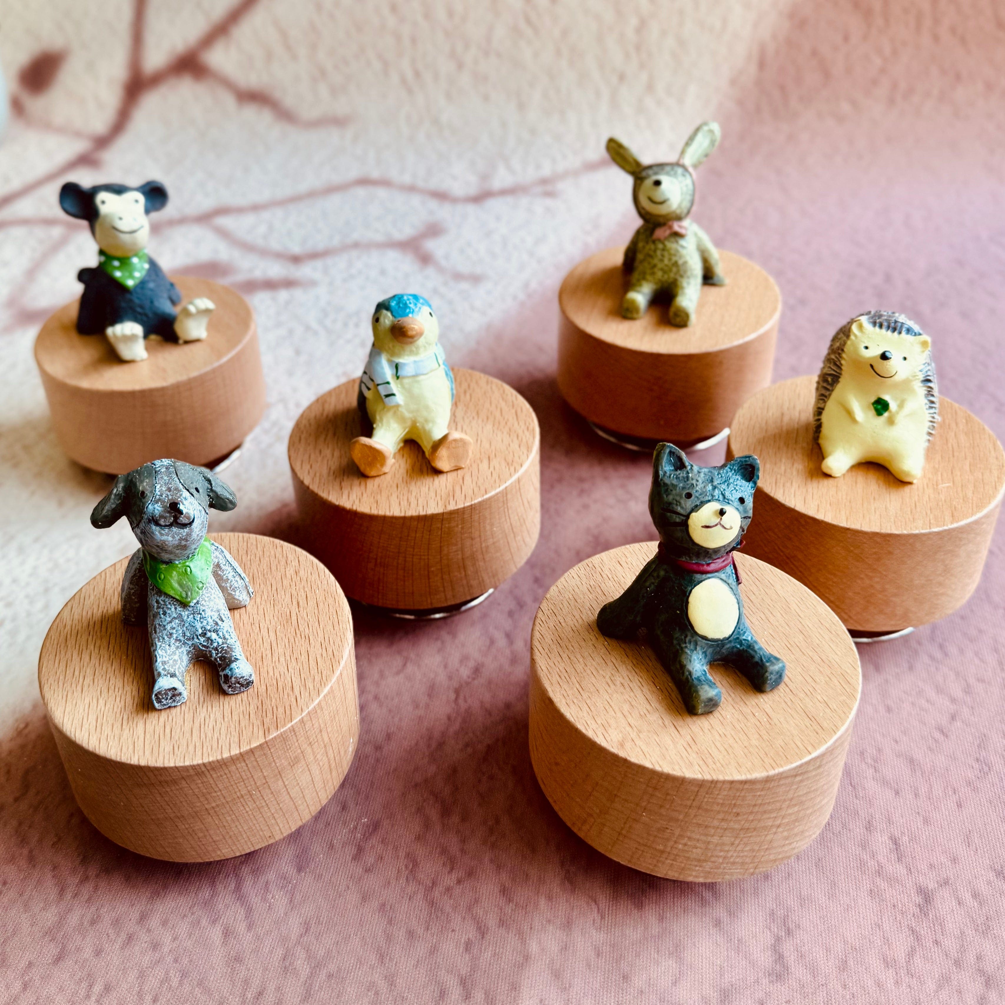 Adorable animal figurines on wooden bases: monkey, penguin, bunny, hedgehog, dog, cat — perfect for musical instruments or decor.
