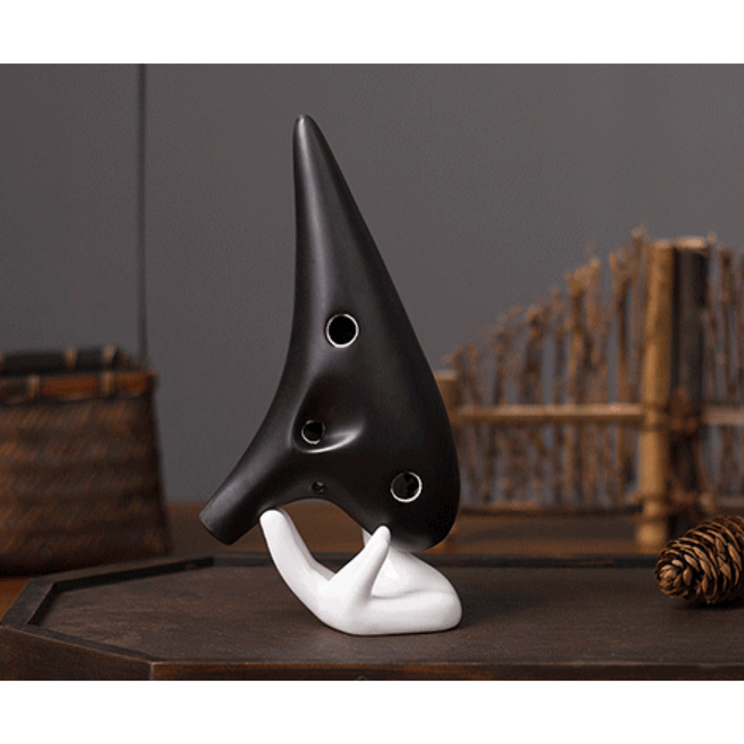 Black ocarina on white hand stand, healing musical instrument for peace and creativity