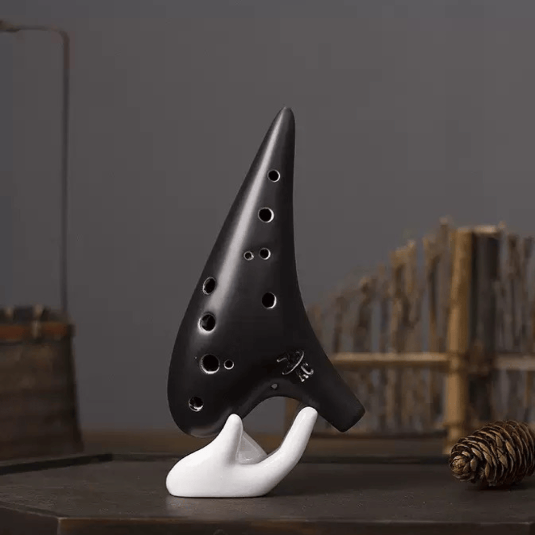 Black ocarina on white stand, healing musical instrument for peace and creativity