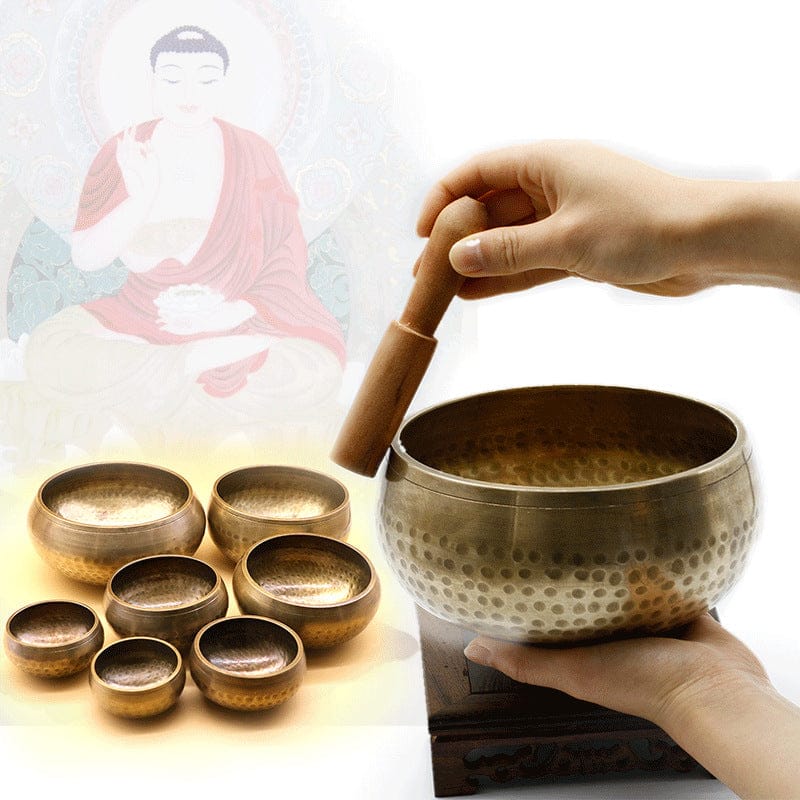Hand striking hammered singing bowl set with Buddha image, ideal for meditation and healing sound therapy