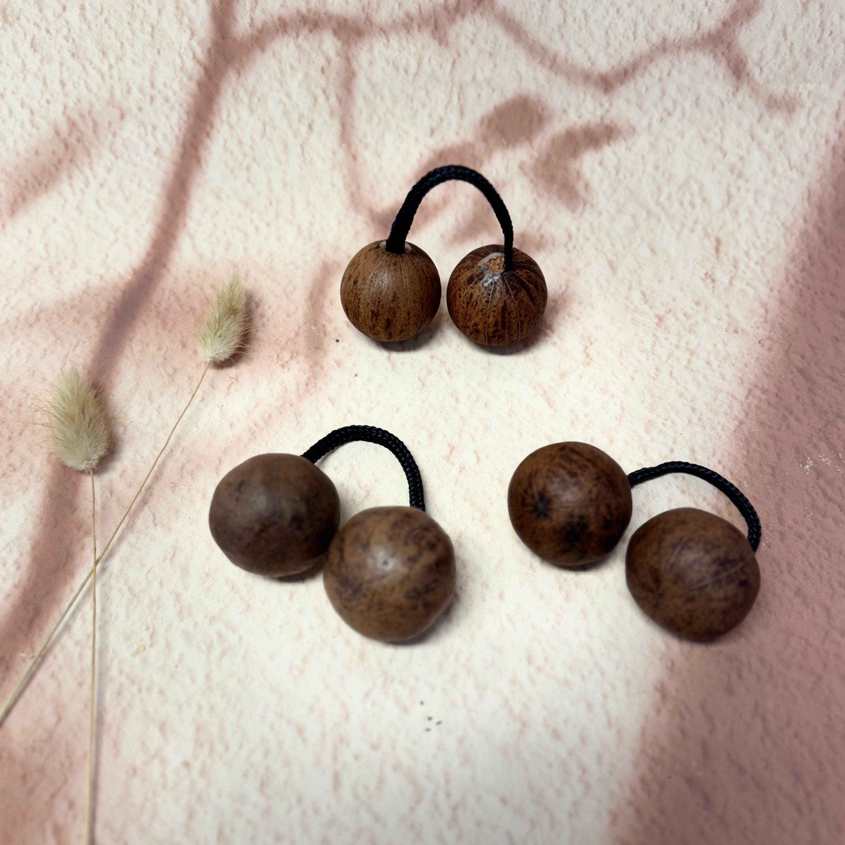 Natural wood percussion balls with black cords, ideal for handpan, kalimba, or meditation sound therapy