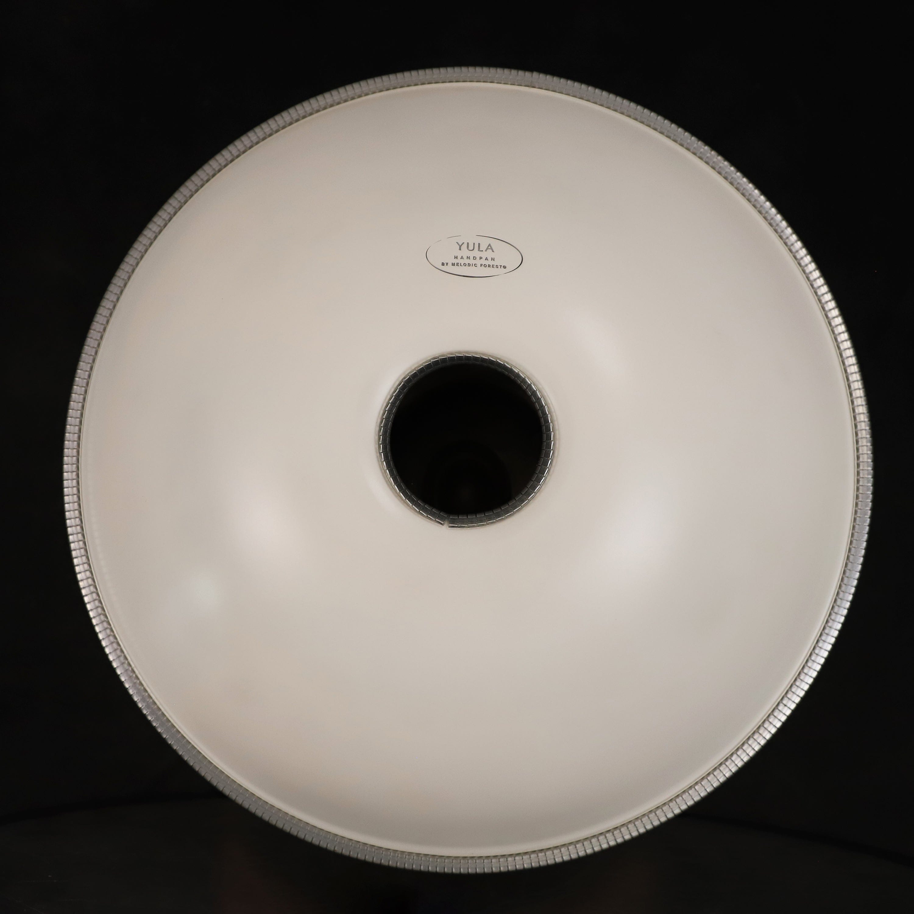 Yula Handpan by Melodic Foresto — sleek white steel tongue drum with central sound hole, ideal for healing music and meditation.