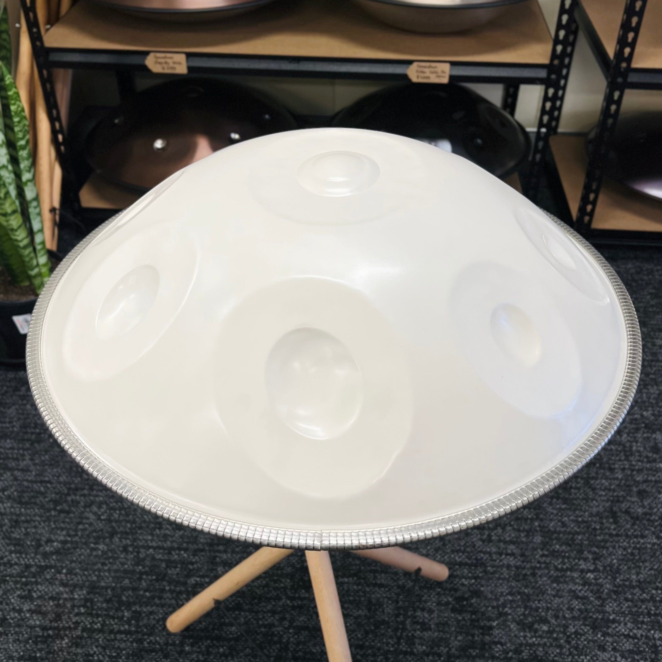 White handpan drum on wooden stand, healing musical instrument for meditation and relaxation