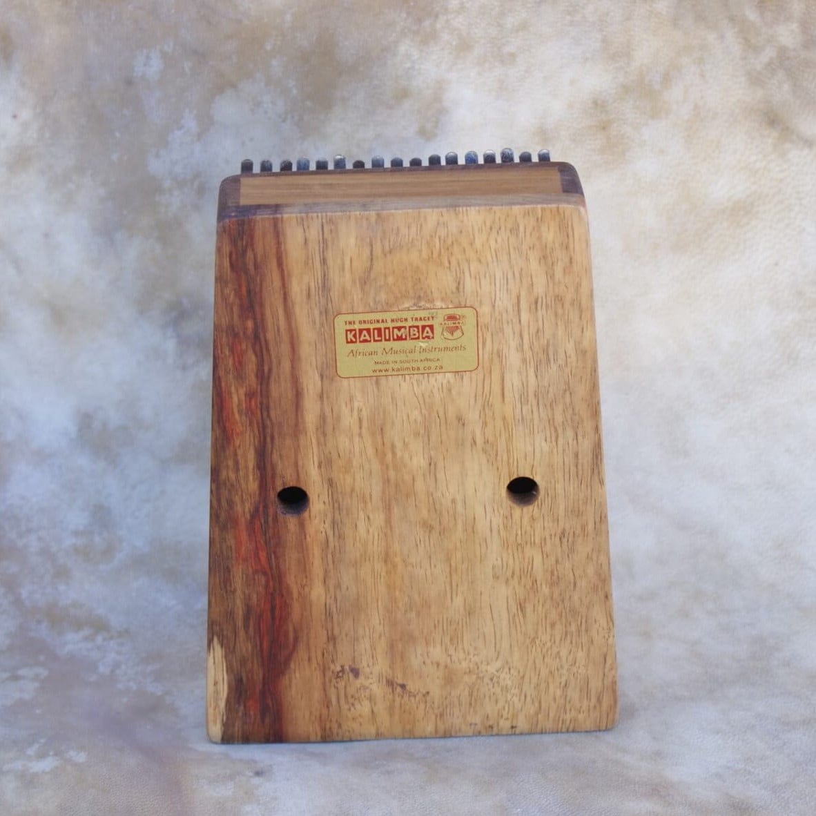 Handcrafted wooden kalimba thumb piano with natural grain and sound holes, ideal for healing music and meditation.