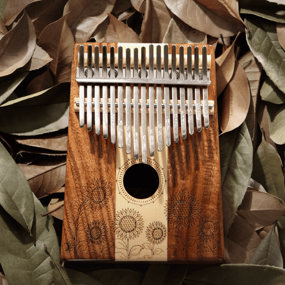 Handcrafted sunflower kalimba with engraved notes, nestled in autumn leaves for serene musical play