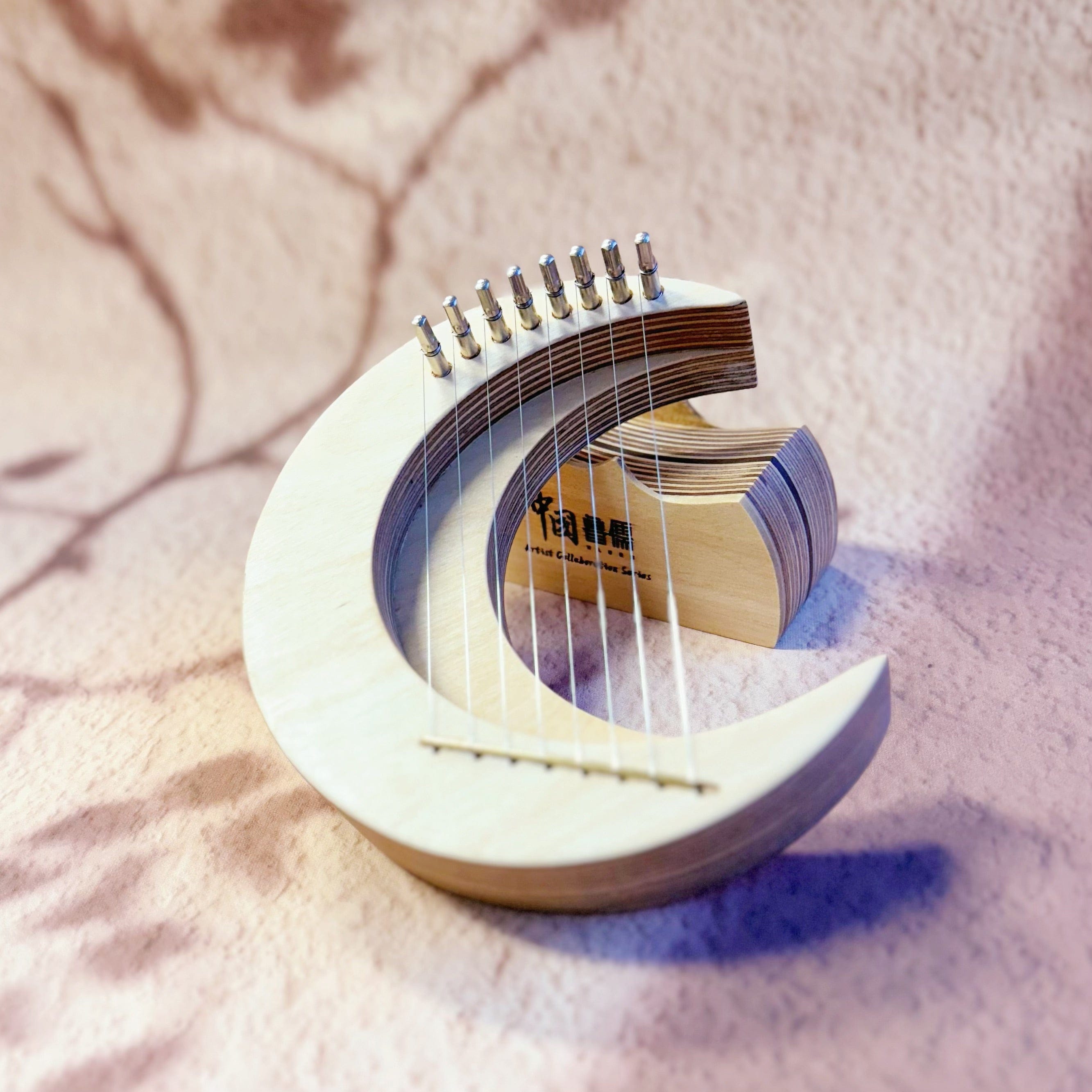 Crescent-shaped wooden lyre harp with strings, designed for healing and meditation music