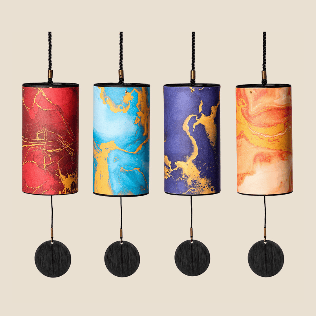 Four colorful marbled wind chimes with black wooden discs, perfect for peaceful outdoor decor and healing soundscapes