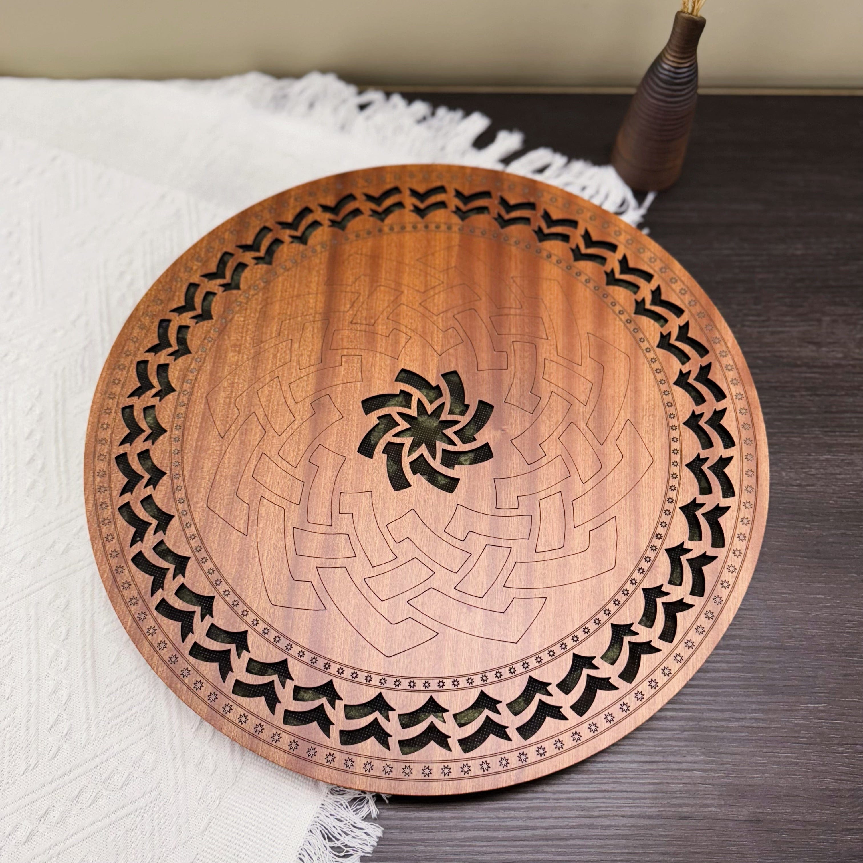 Handcrafted wooden tongue drum with intricate geometric carvings, resting on a white textile for serene sound healing.