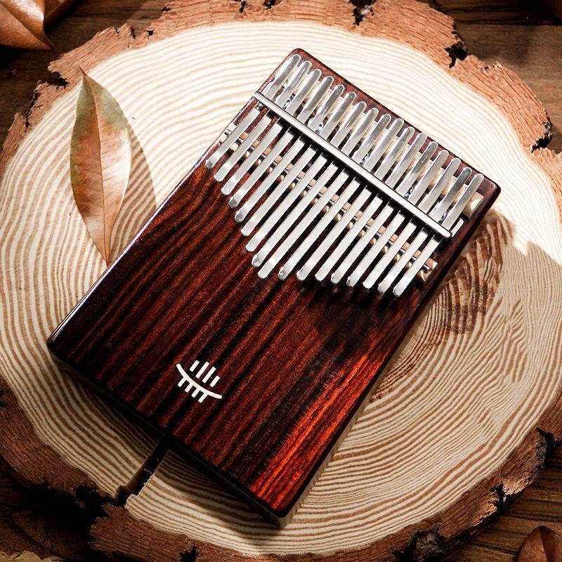 Handcrafted kalimba thumb piano on rustic wood slice, natural leaf accent, healing musical instrument
