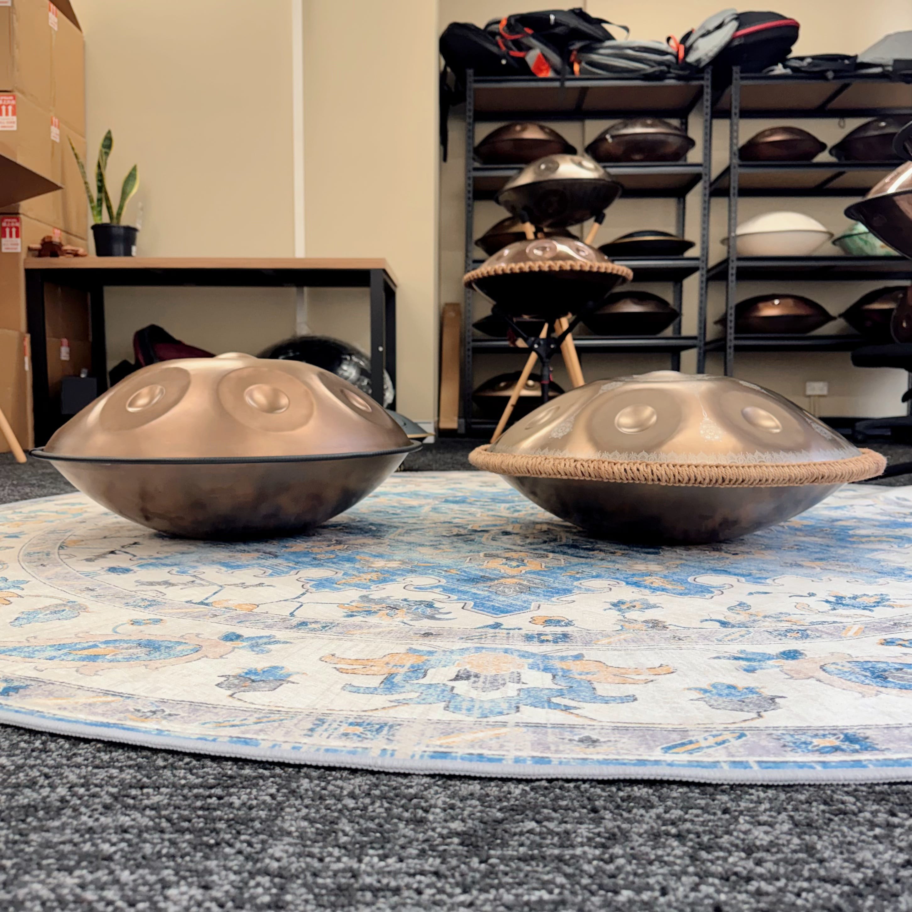 Riza Premium 55cm gold handpan beside another model, showing its larger and deeper sound chamber