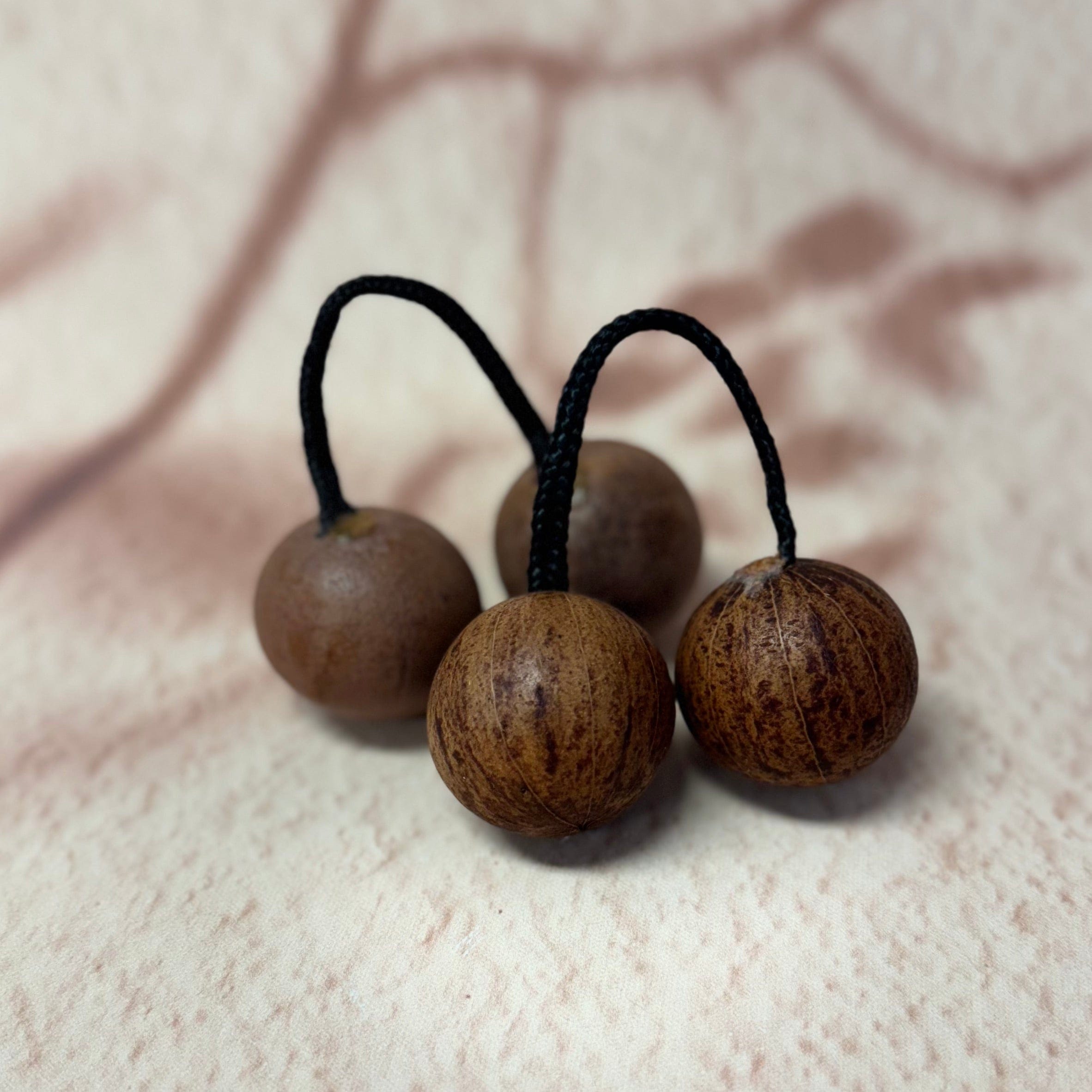 Natural wooden percussion balls with black cords, ideal for handpan or kalimba rhythm accessories