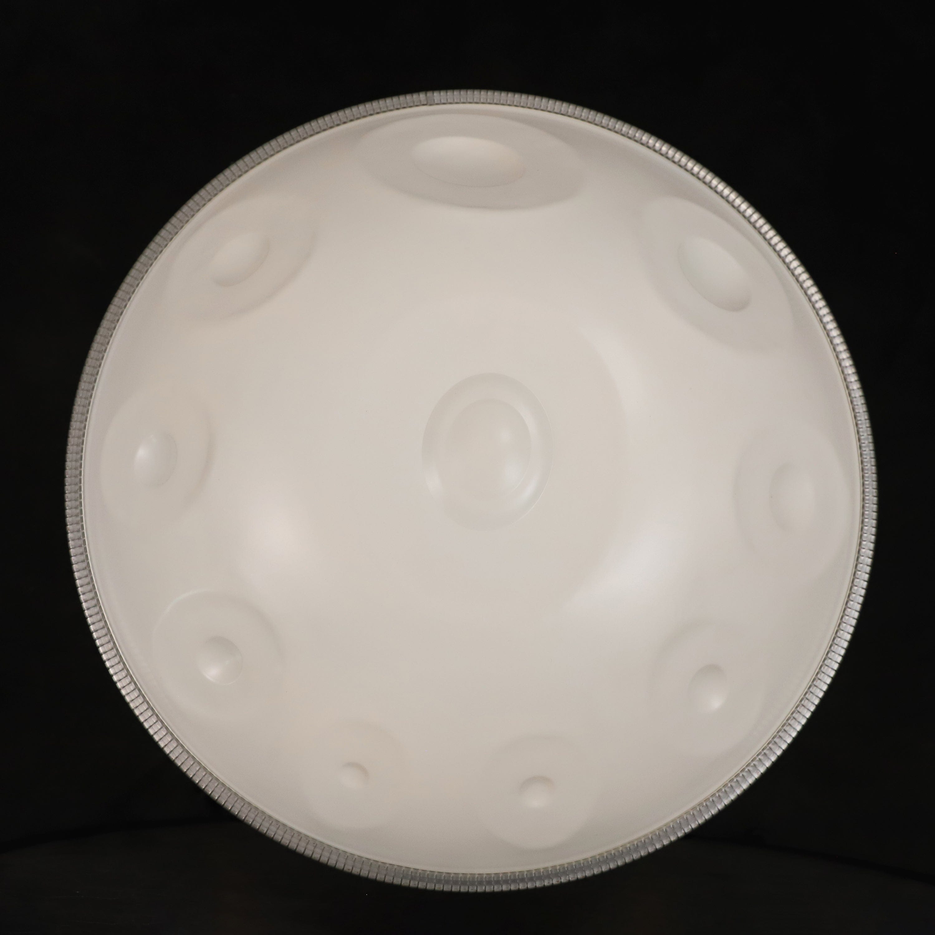 White handpan drum with silver rim, healing musical instrument for meditation and relaxation