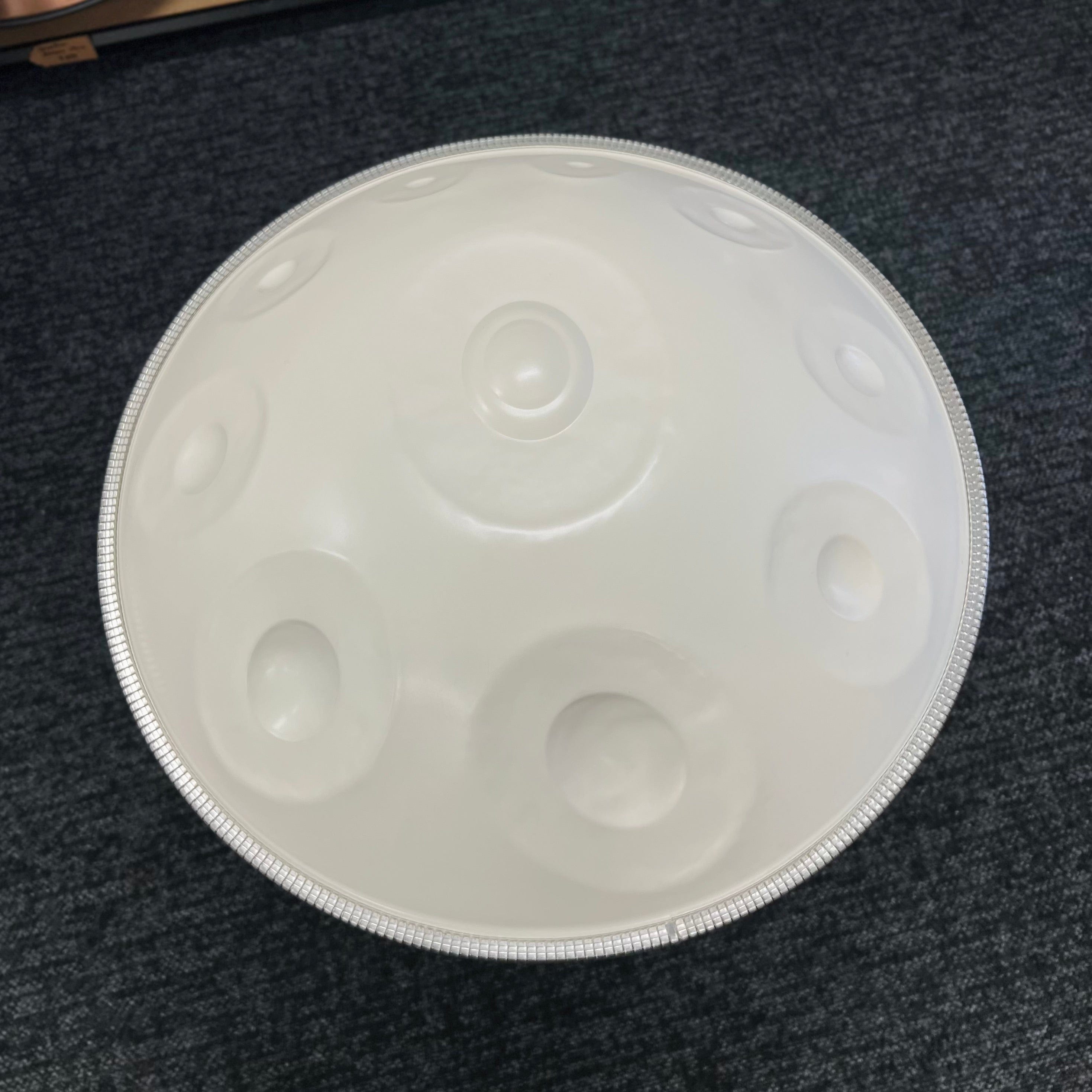White handpan drum with silver rim, healing musical instrument for meditation and relaxation